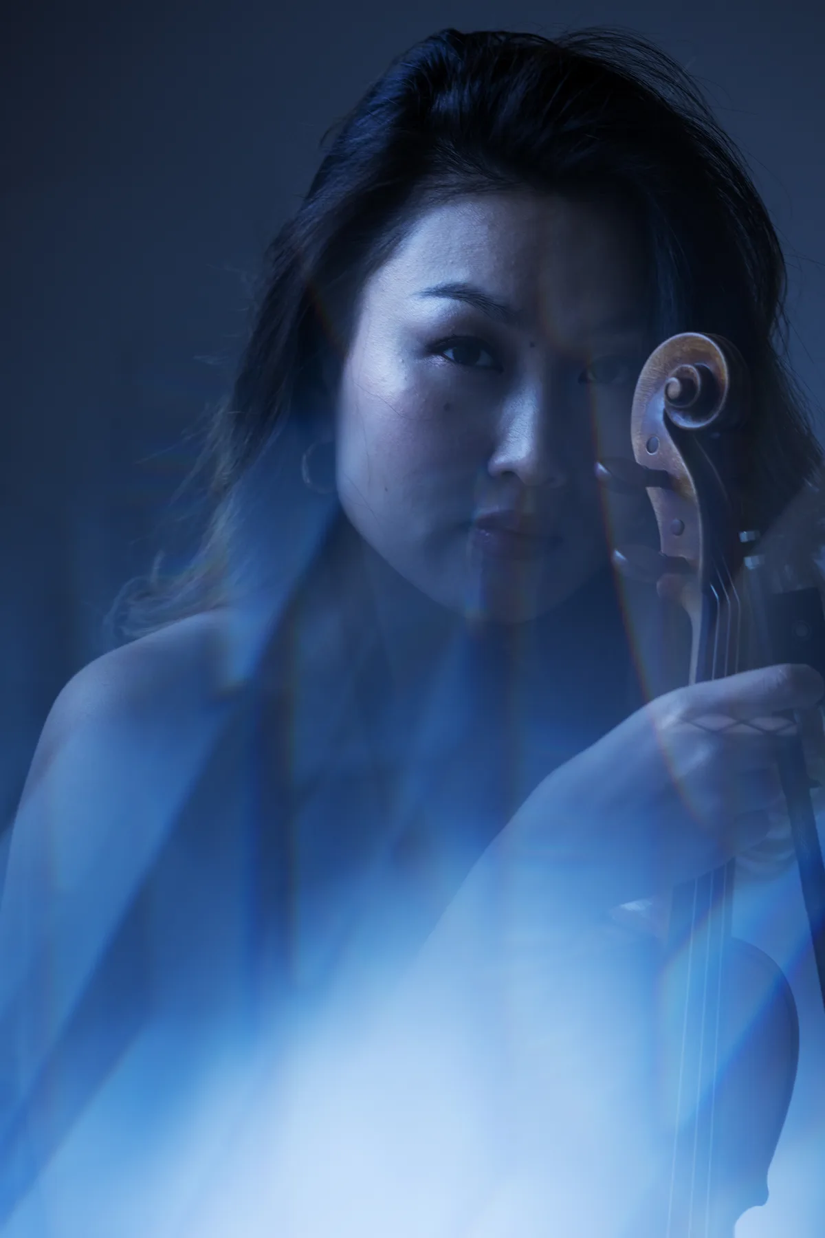 Olesya Lisovskaya verbindet ihre Interessen in der Fotografie: Experimente mit Licht und Farben. Eine Musikerin mit ihrer Geige.
